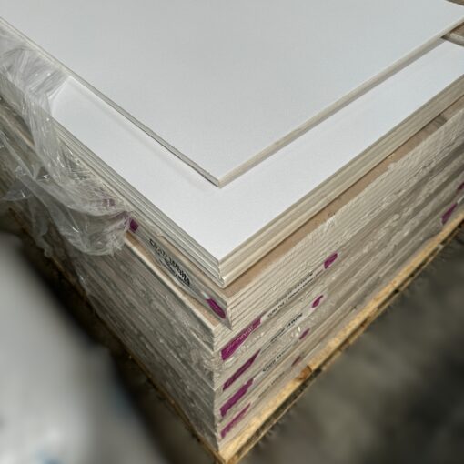 A pallet of Siniat Etex 12mm White Vinyl Ceiling Tiles stacked neatly, showing the top tile with a smooth white surface.